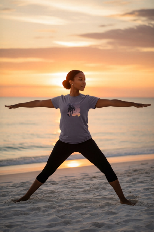 Woman in a Shell Hash Republic Comfort Colors Neon T-Shirt in Sunset Wine with a retro graphic tee design, doing yoga on a beach at sunset
