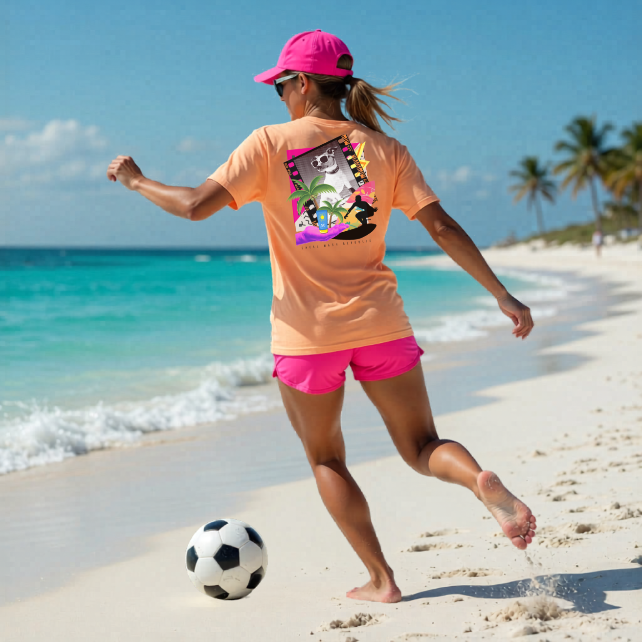 Woman in Shell Hash Republic Comfort Colors T-Shirt with Trop Pop Art design playing soccer on a beach