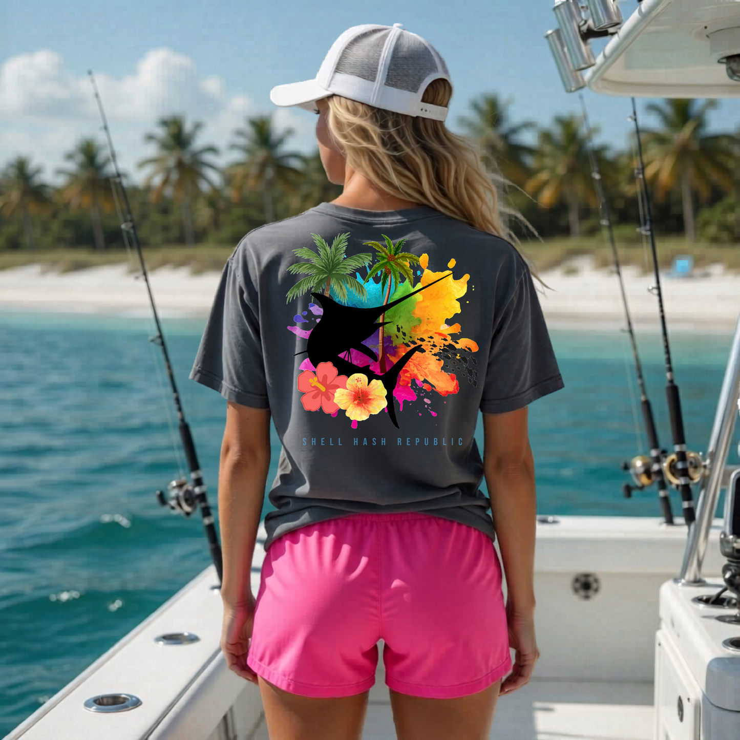 Shell Hash Republic Comfort Colors T-Shirt in graphite with a Tropical Marlin Splash graphic on the back, worn by a person on a boat with fishing rods