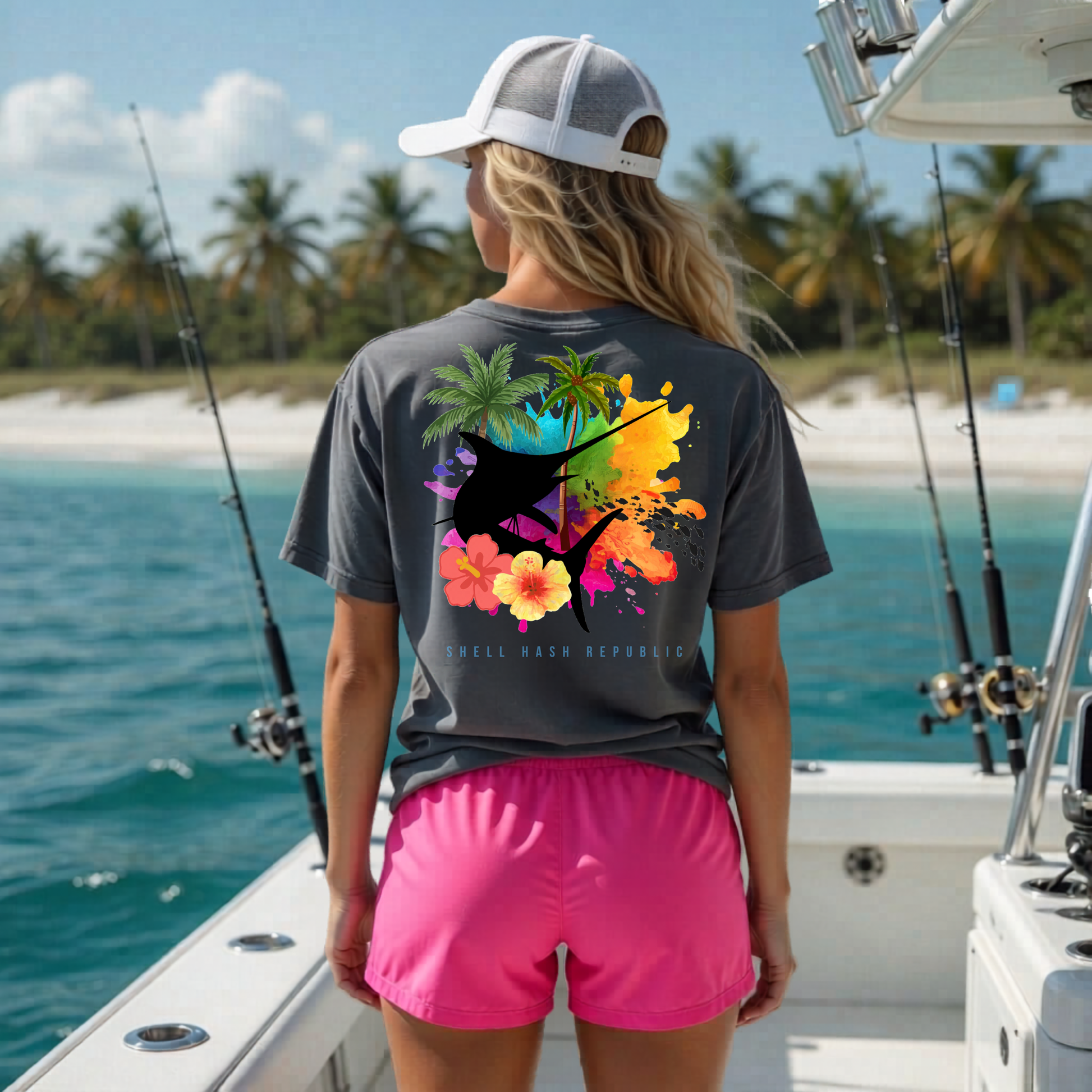 Shell Hash Republic Comfort Colors T-Shirt in graphite with a Tropical Marlin Splash graphic on the back, worn by a person on a boat with fishing rods